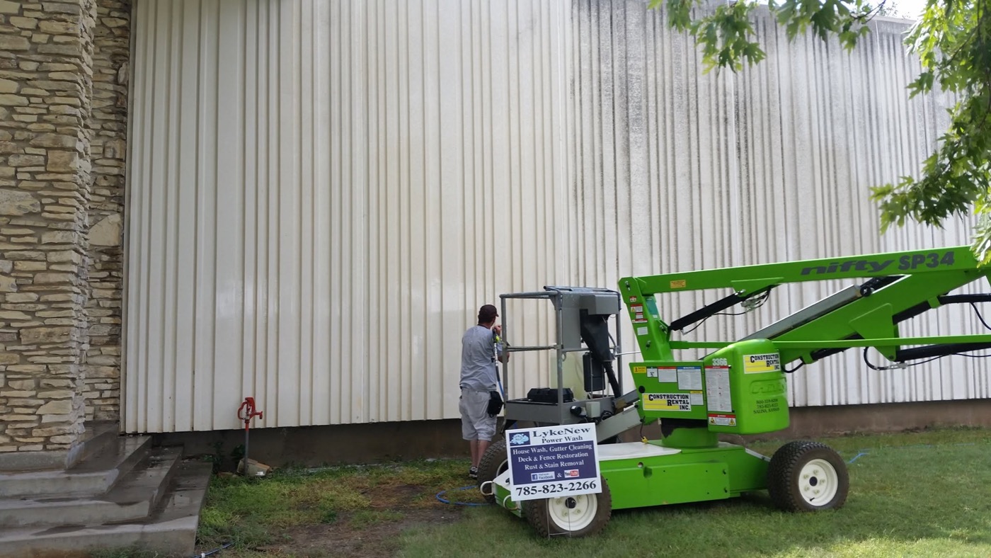 washing streaked metal panel siding on a commercial building in Salina, KS from a lift